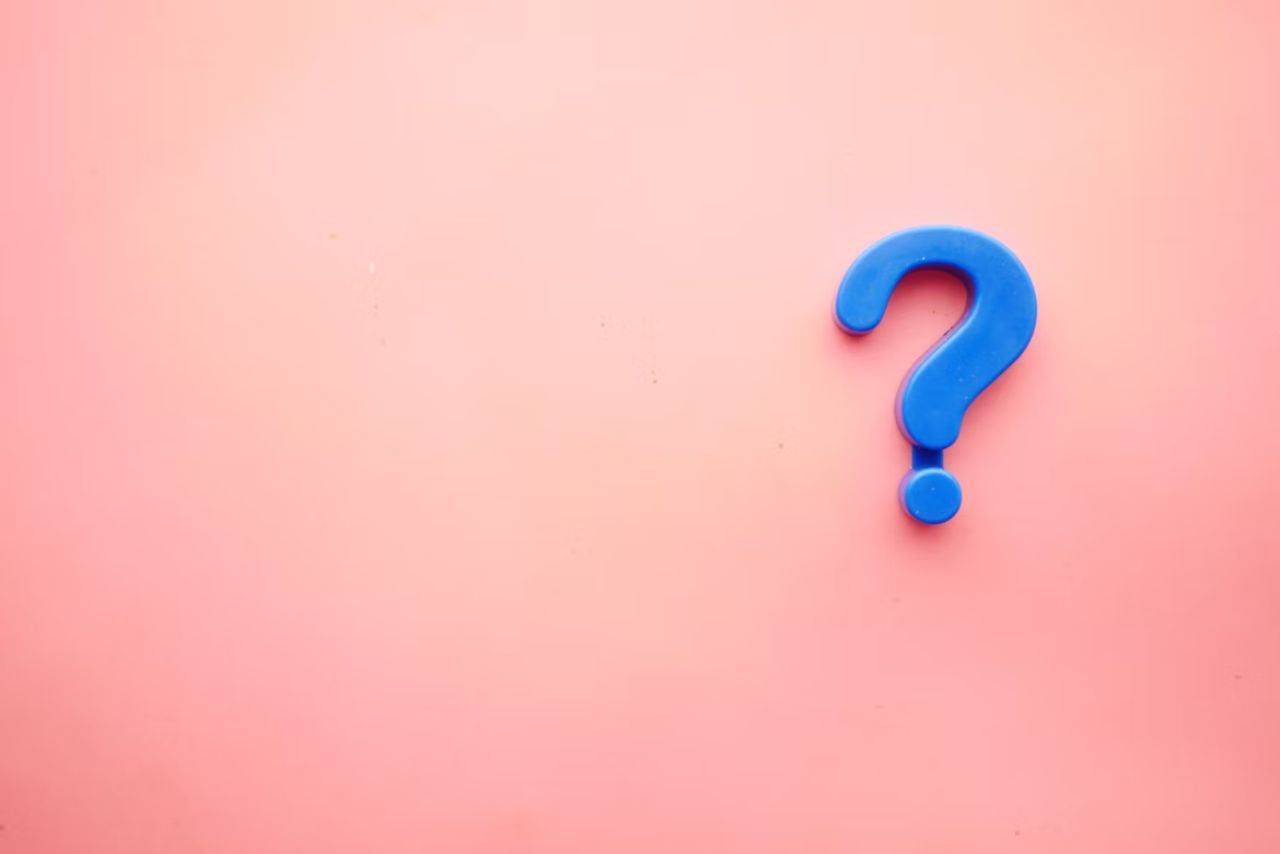 Blue questions mark against a pink background