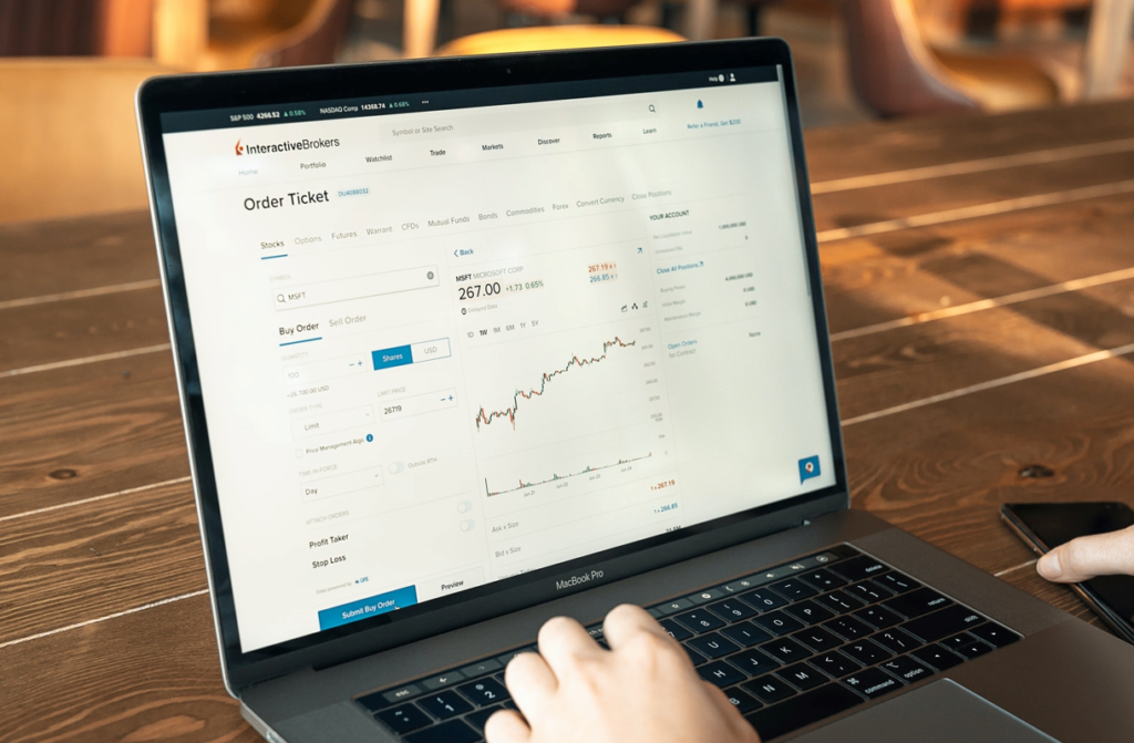 Black laptop on wooden table with data related to B2C company on it