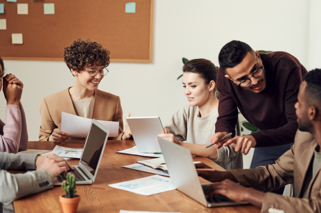 Several young professionals sitting at an office table discussing application integration