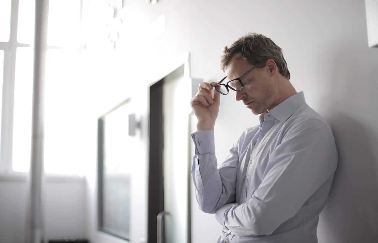 White male CIO in buttoned-down shirt and glasses frustrated from not seeing value from application modernization