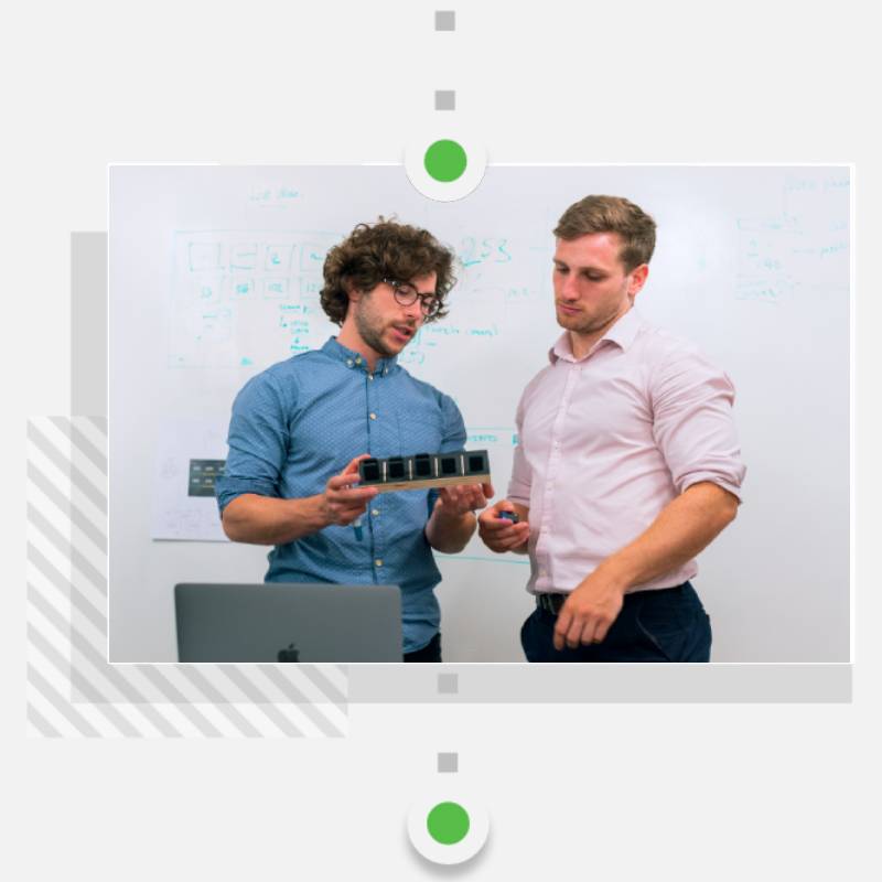 Two young male professionals reviewing logistics of digital product