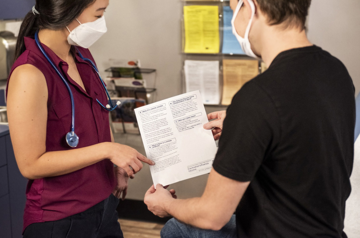Doctor helping patient understand medical document