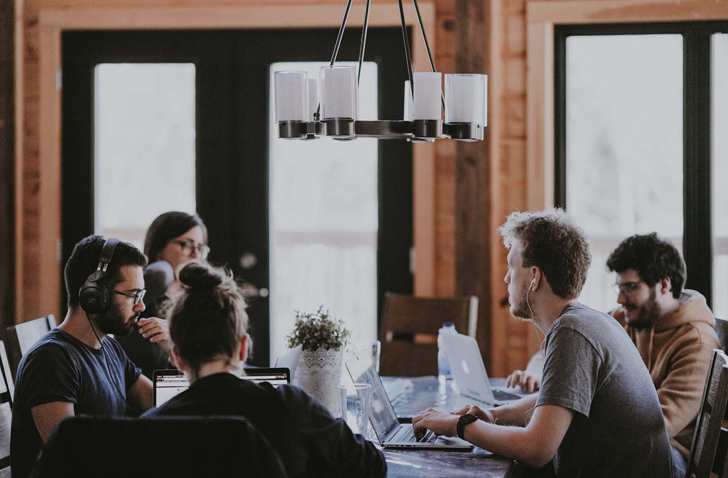 Tech leaders at a table debating benefits of dedicated teams