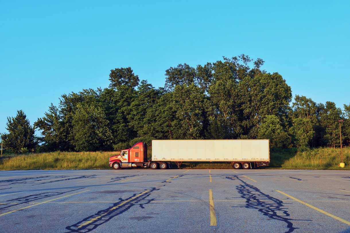 Truck driver taking a break at a rest stop, being documented by a digital product we designed for our logistics client