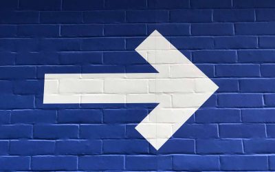 White arrow against a blue background, symbolizing application modernization trends moving businesses forward