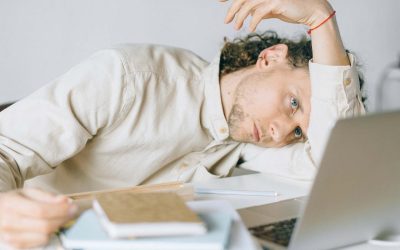 Young professional laying his arm and head on his desk, tired from change fatigue