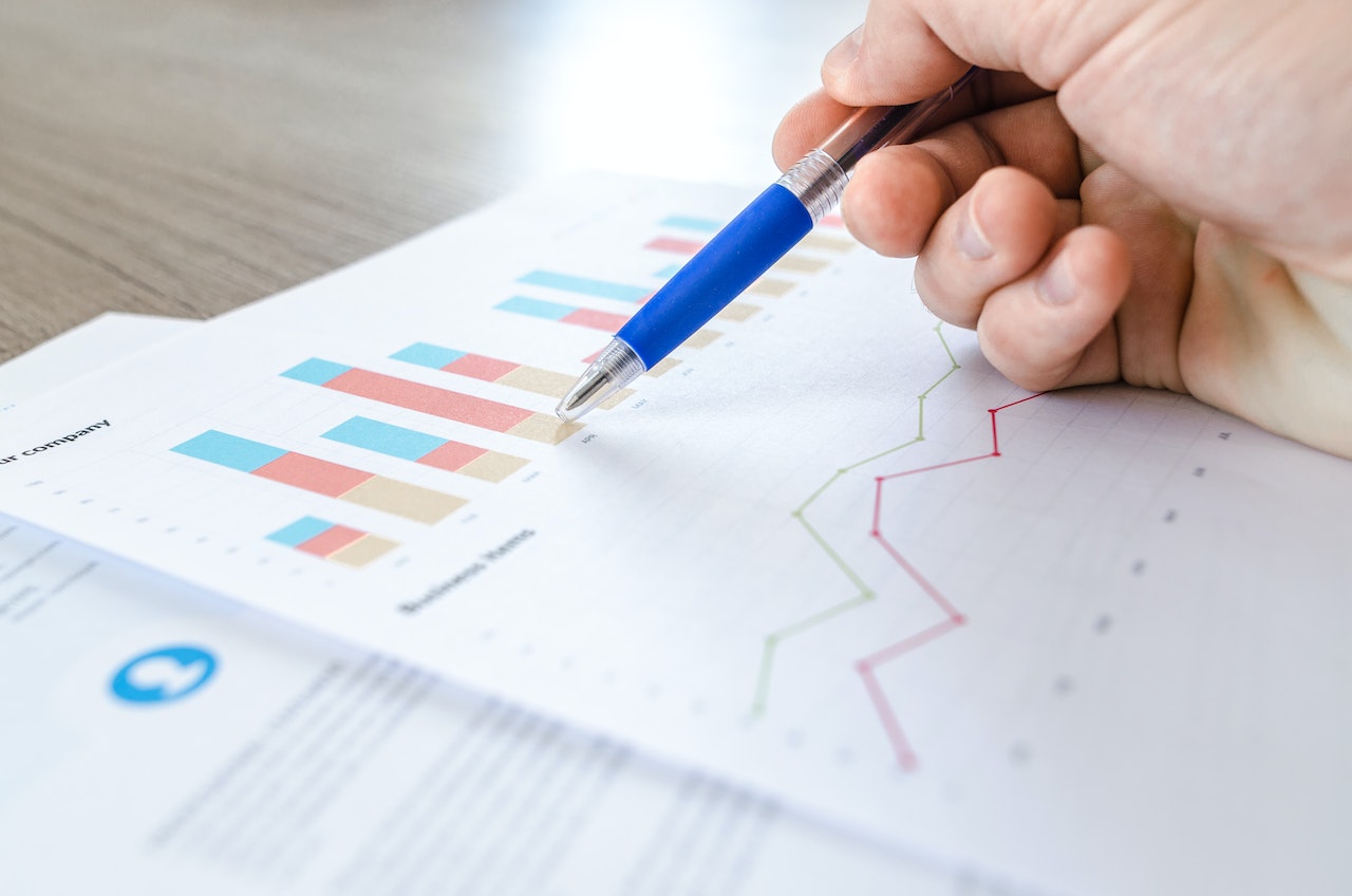 Professional reviewing printed-out spreadsheets with data related to digital maturity initiative