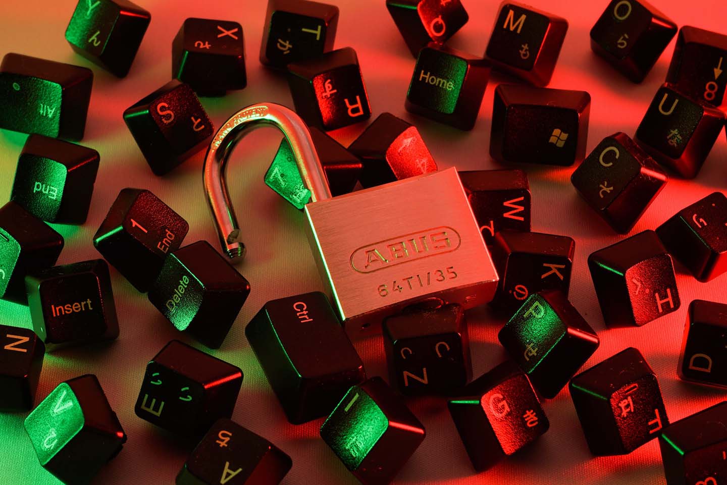 Open lock surrounded by keyboard keys, representing a security breach