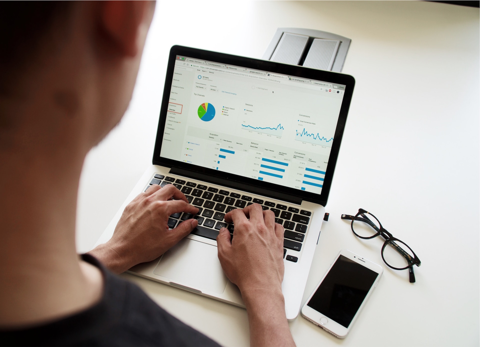 Hands of male professional and female professional reviewing digital product KPIs