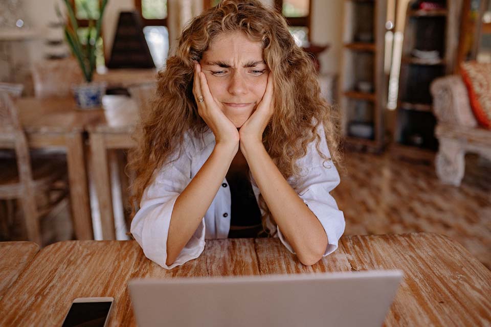 Woman frustrated while trying to find the data she is looking for on her laptop