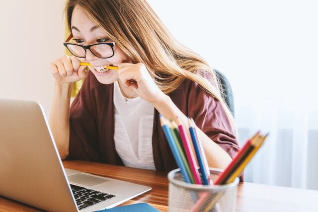 Woman sitting at table looking at laptop in frustration while dealing with low-quality data