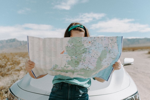 Woman beside her car reviewing a roadmap, symbolizing insurance companies’ journey to becoming data-driven.